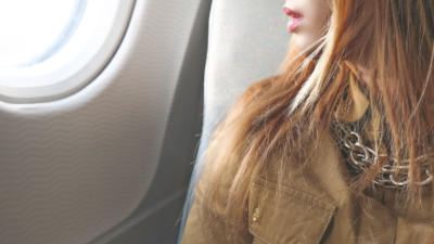 close up woman looking out plane window